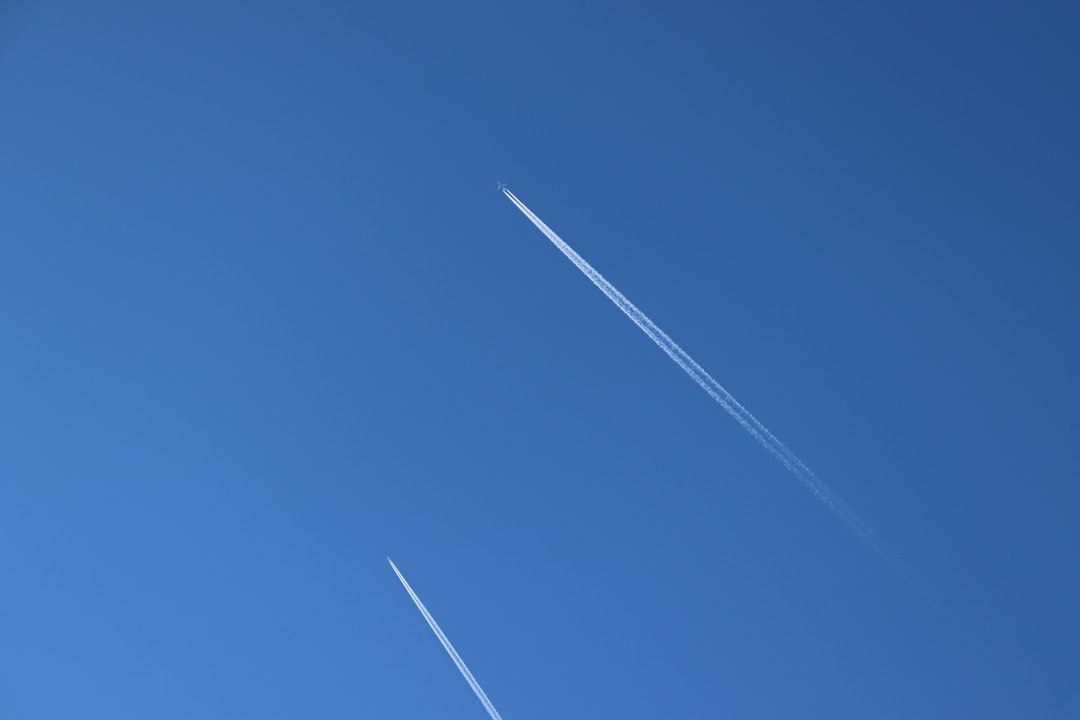 an airplane is flying in the blue sky,