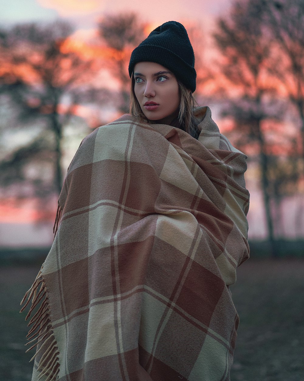 a woman wrapped in a blanket in a park