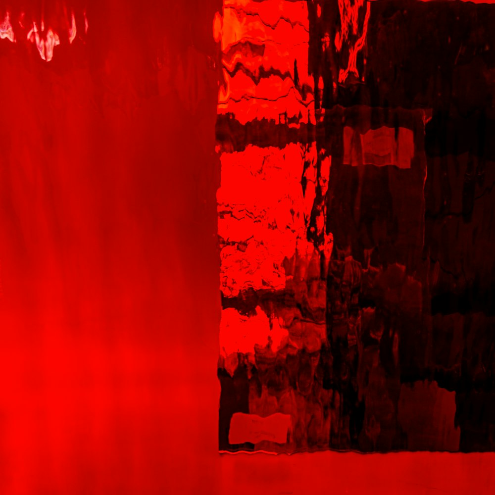 a red and black abstract painting of a brick wall