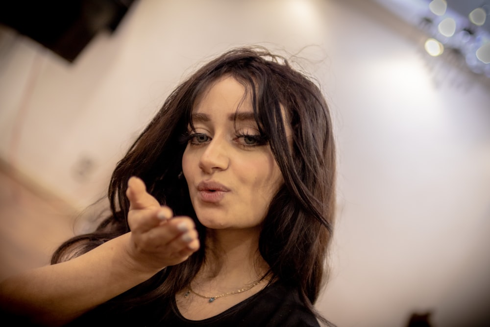 a woman with long hair pointing at something