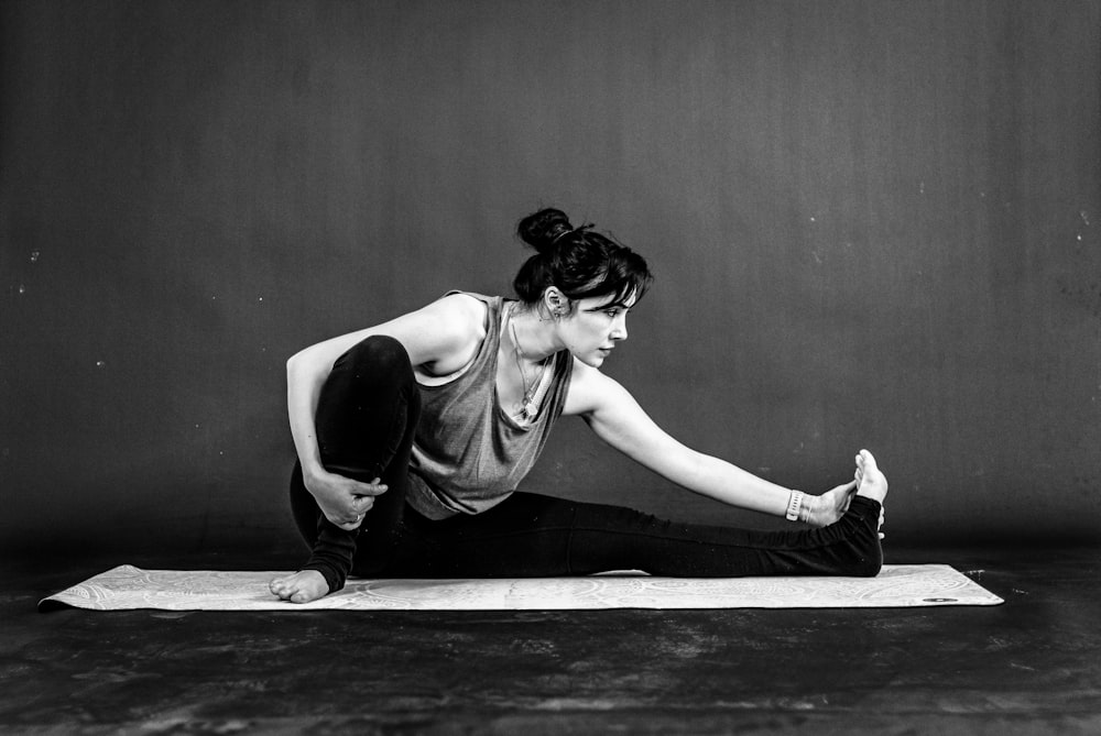 a woman is doing a yoga pose on a mat