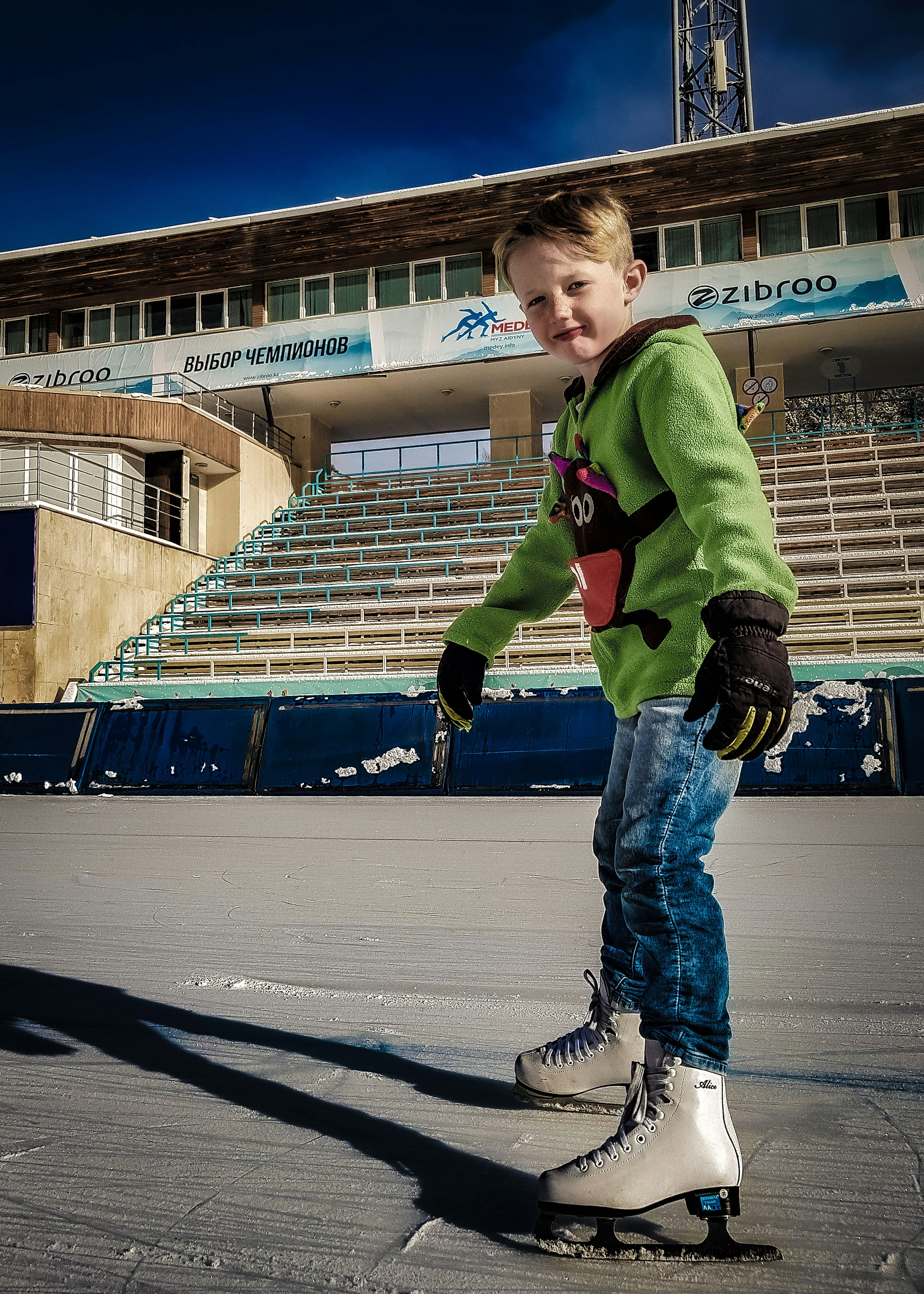 um menino que anda de skate na frente de um estádio