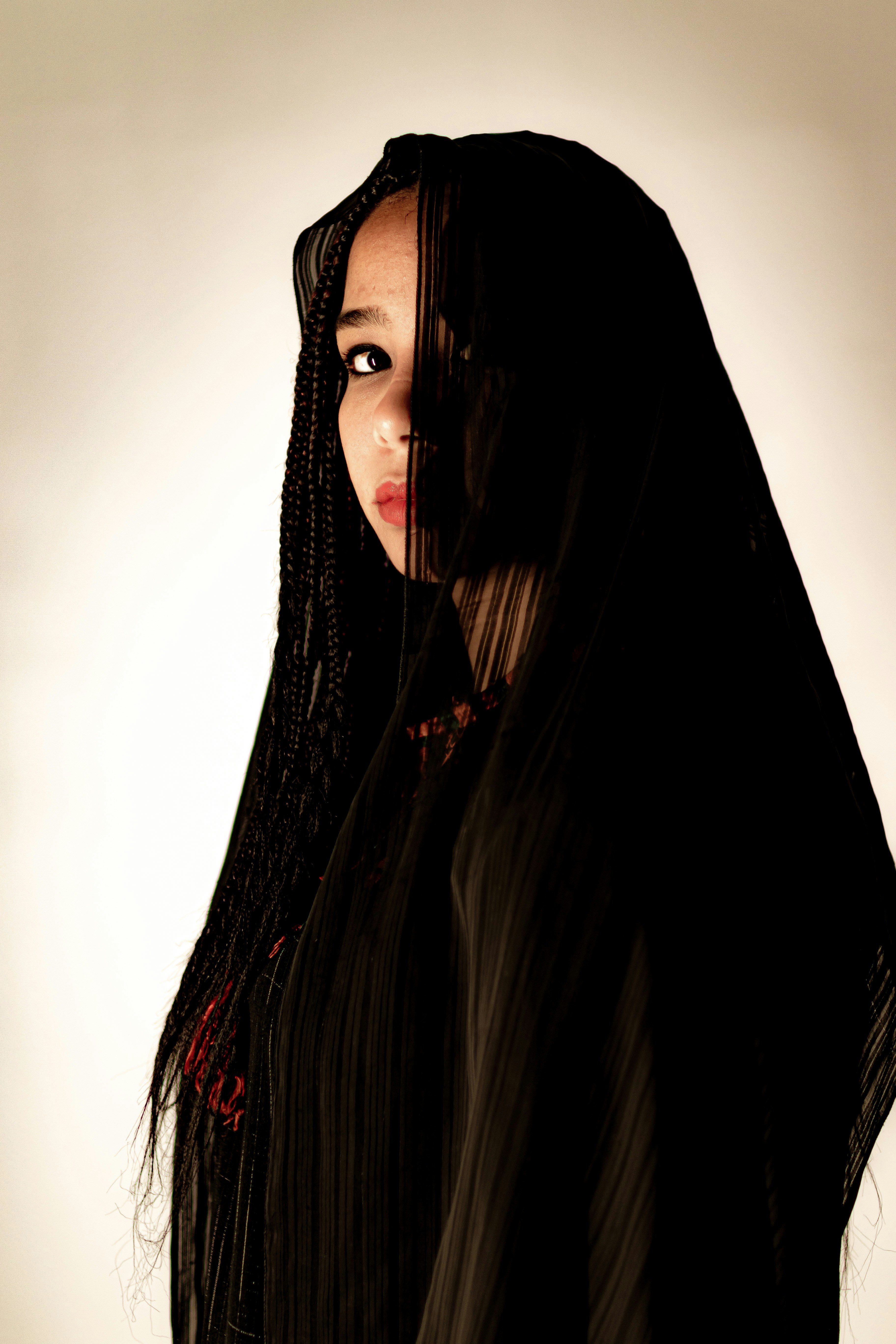 a woman with long black hair wearing a black veil