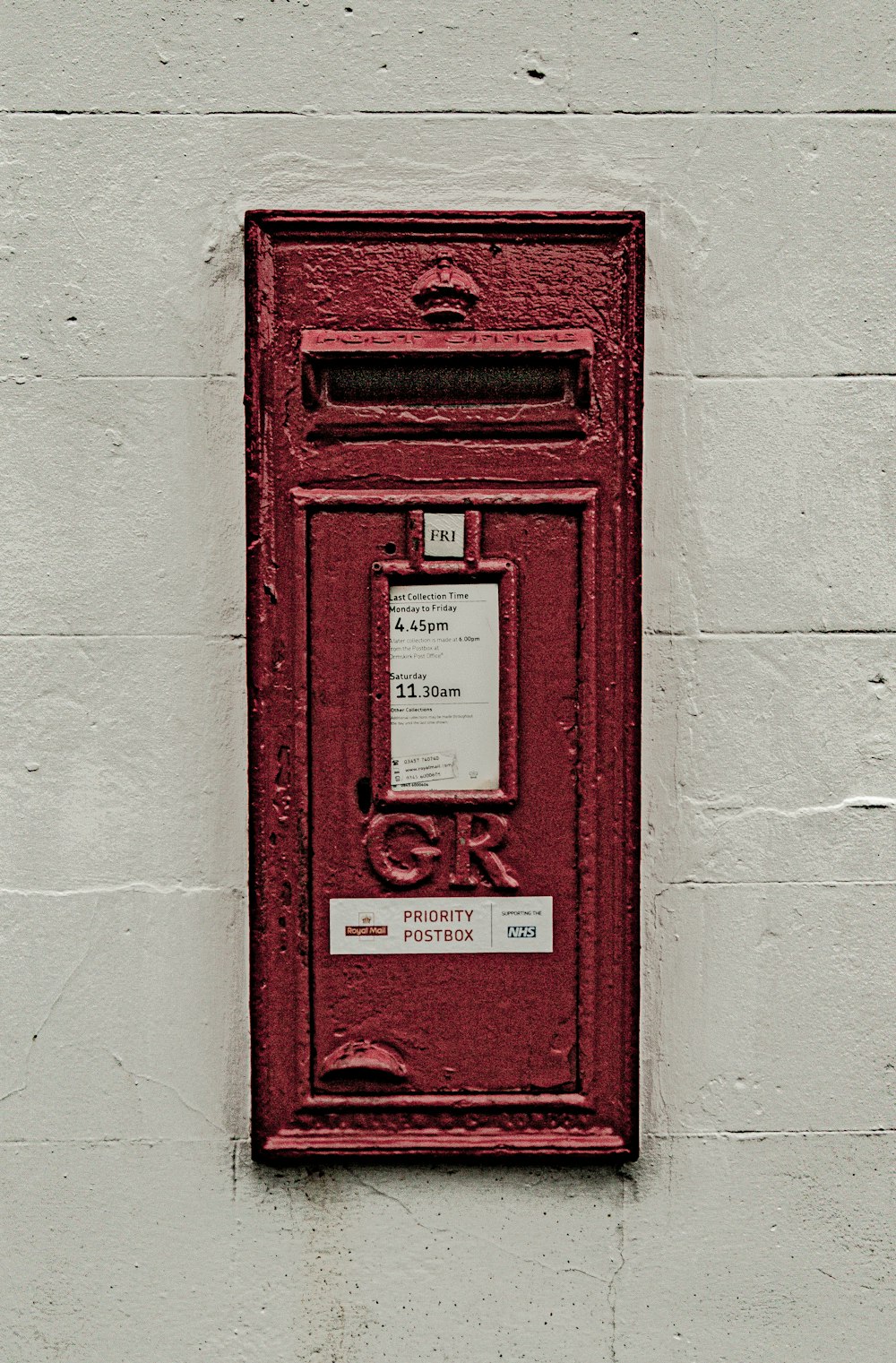 a red mailbox mounted to a white wall