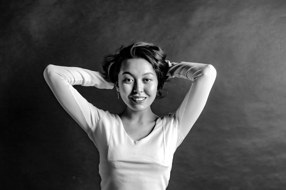 a black and white photo of a woman with her hands on her head