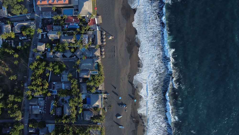 an aerial view of a beach with houses next to the ocean