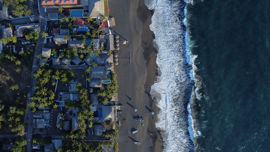an aerial view of a beach with houses next to the ocean,