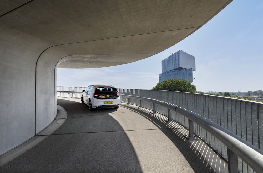 a white van driving down a road next to a tall building