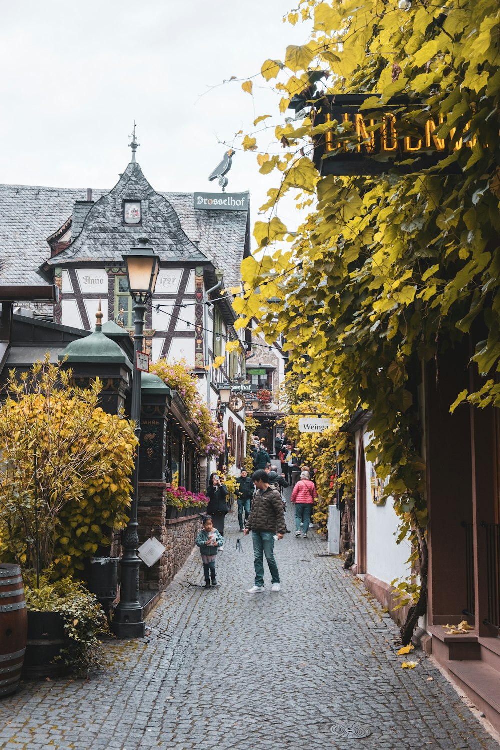 a couple of people walking down a cobblestone street