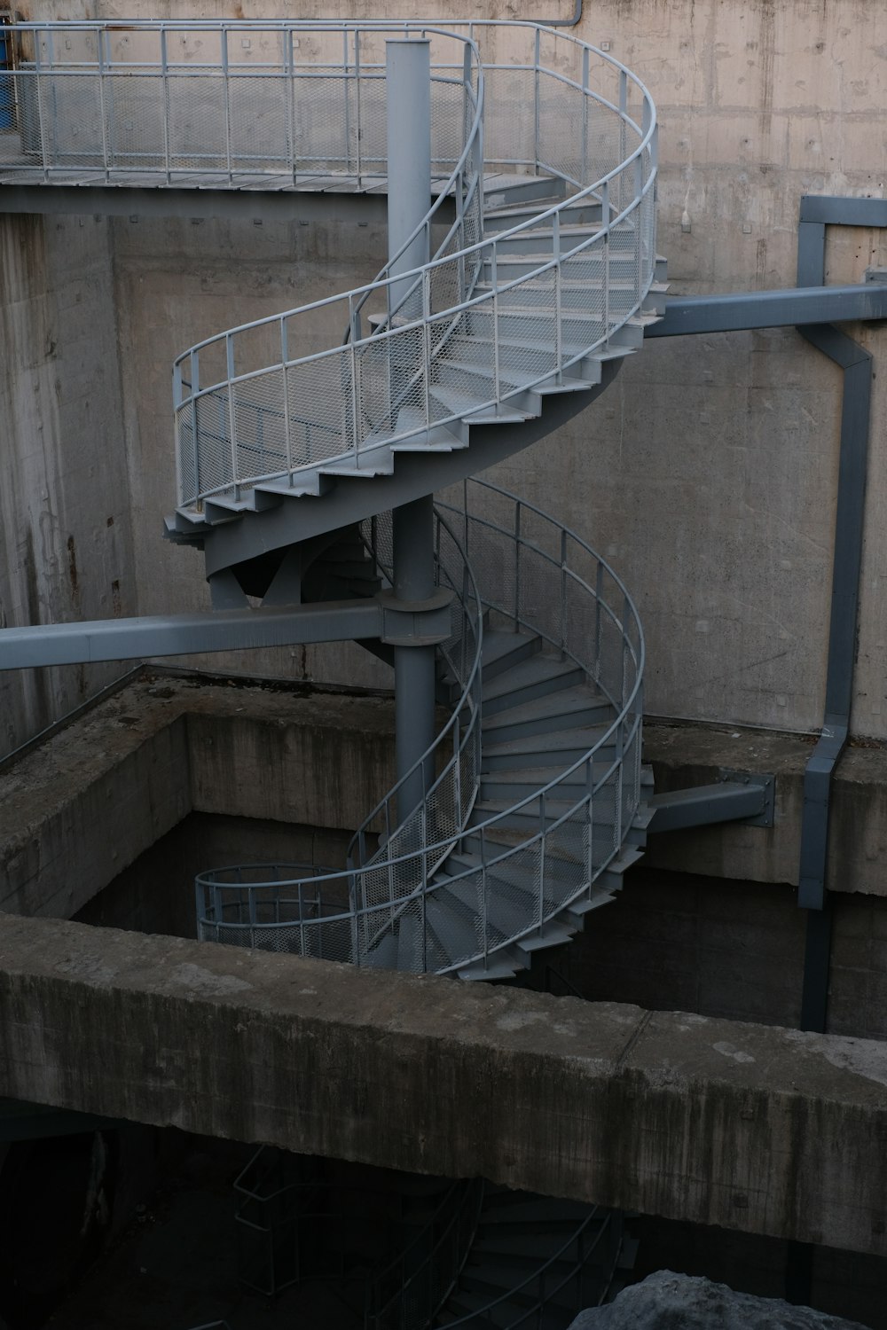 a spiral staircase going up a concrete wall
