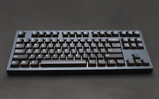 a black computer keyboard sitting on top of a table