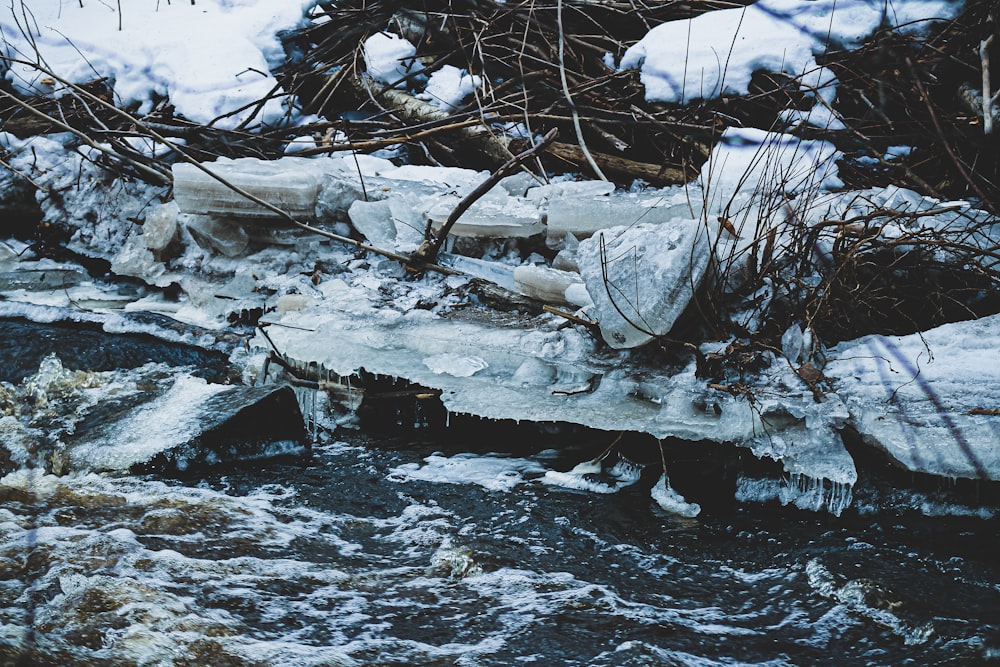 a stream of water surrounded by ice and snow