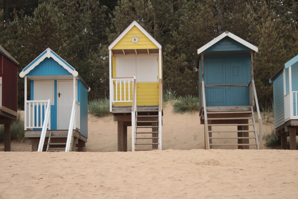 a row of beach huts sitting on top of a sandy beach