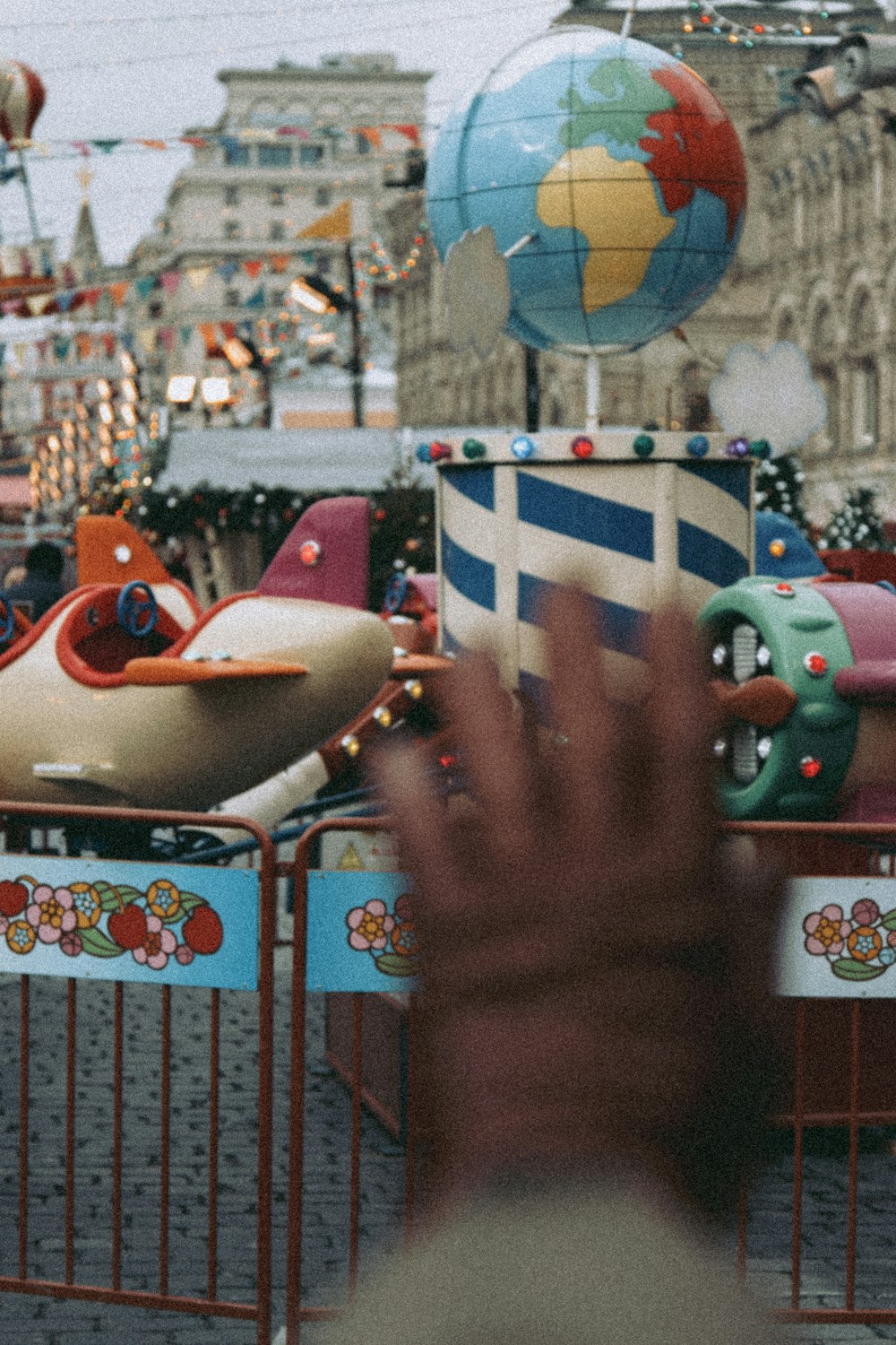 a person is waving at a carnival ride
