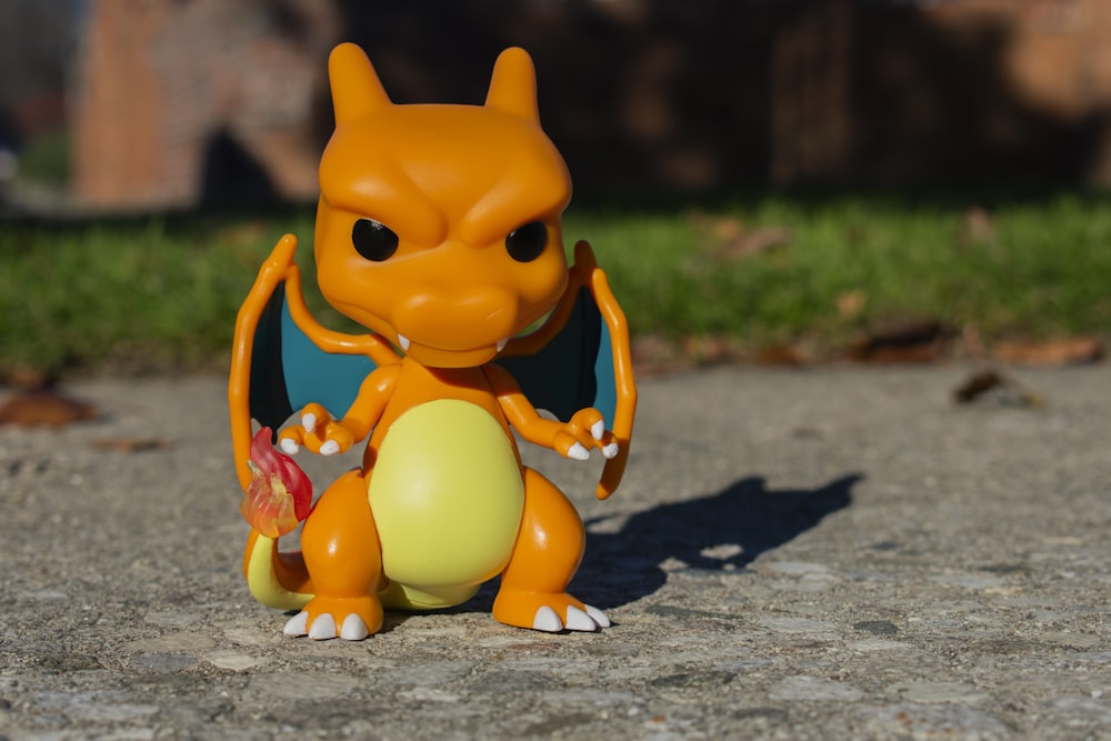 an orange toy sitting on top of a cement ground