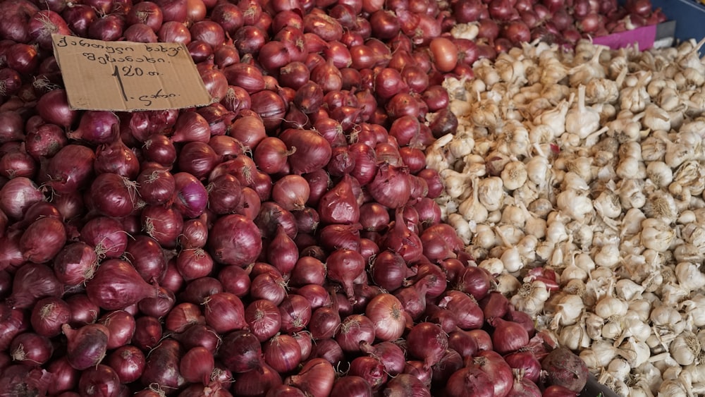 a pile of onions and garlic on display at a market