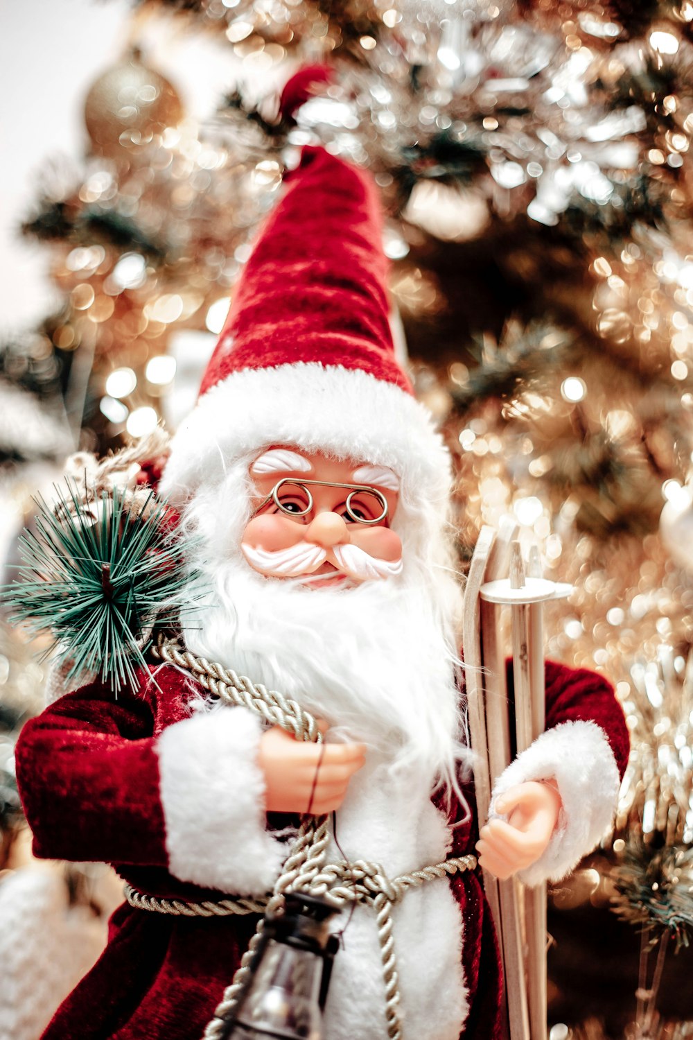 a close up of a santa clause near a christmas tree