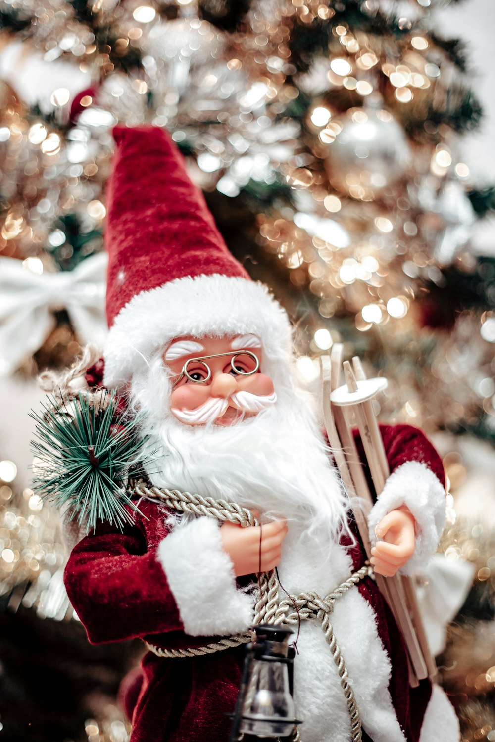 a close up of a santa clause near a christmas tree