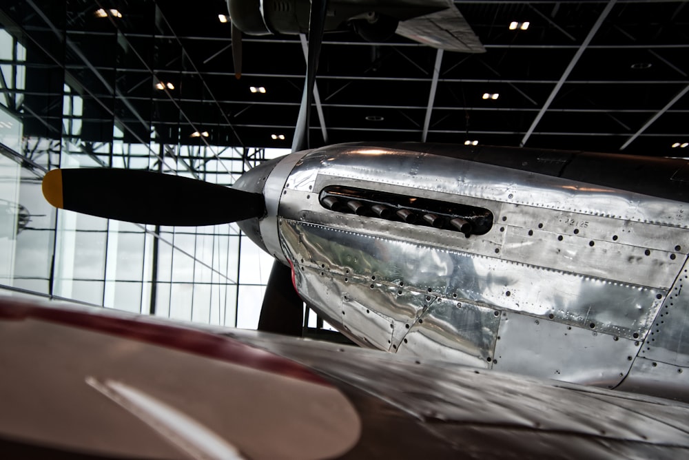 a silver airplane parked inside of a building