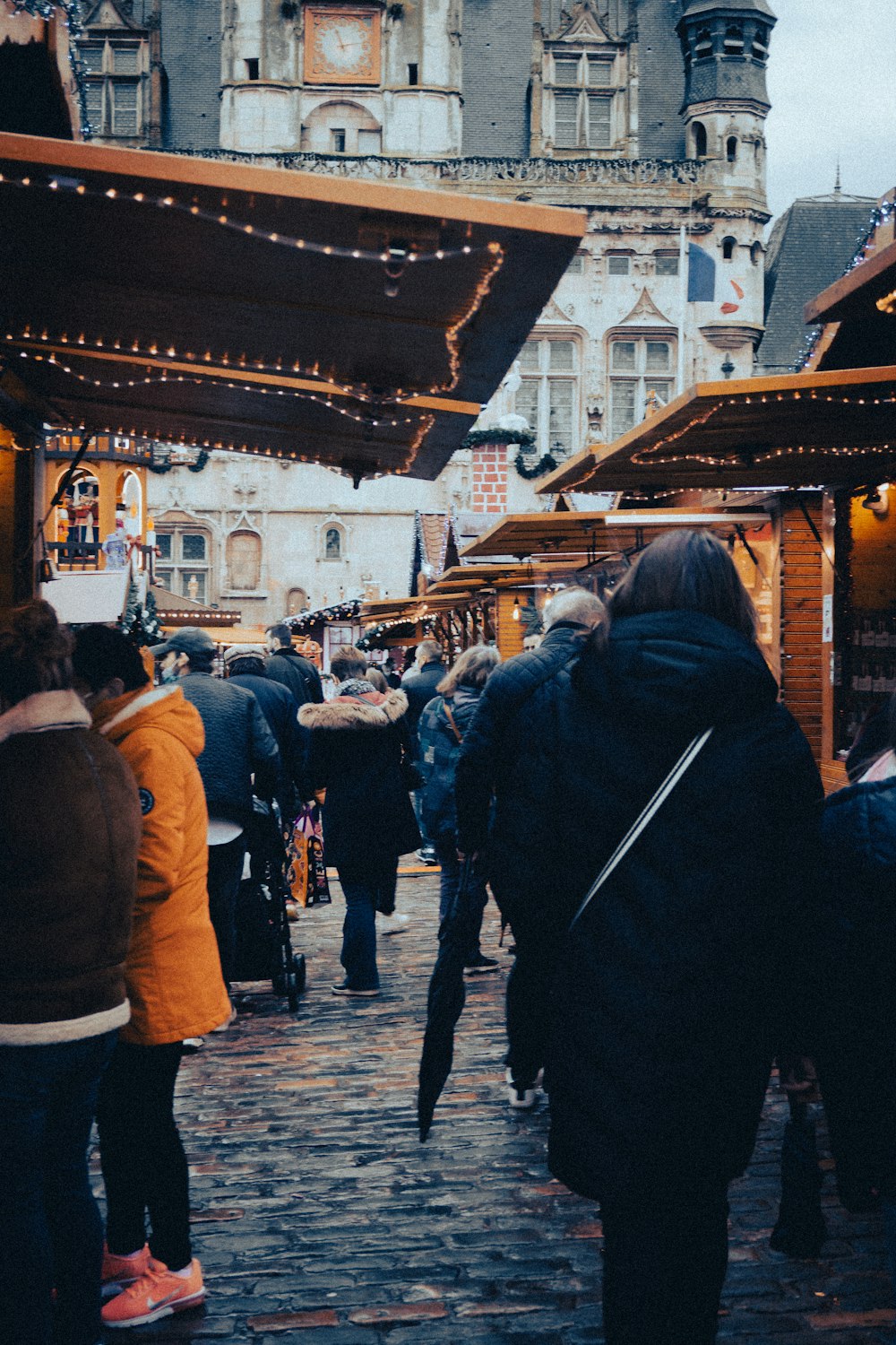 a crowd of people walking down a street next to buildings