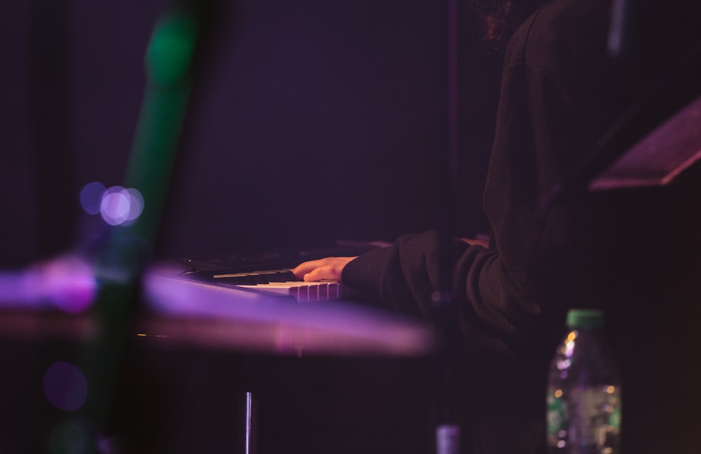 a person playing a piano in a dark room