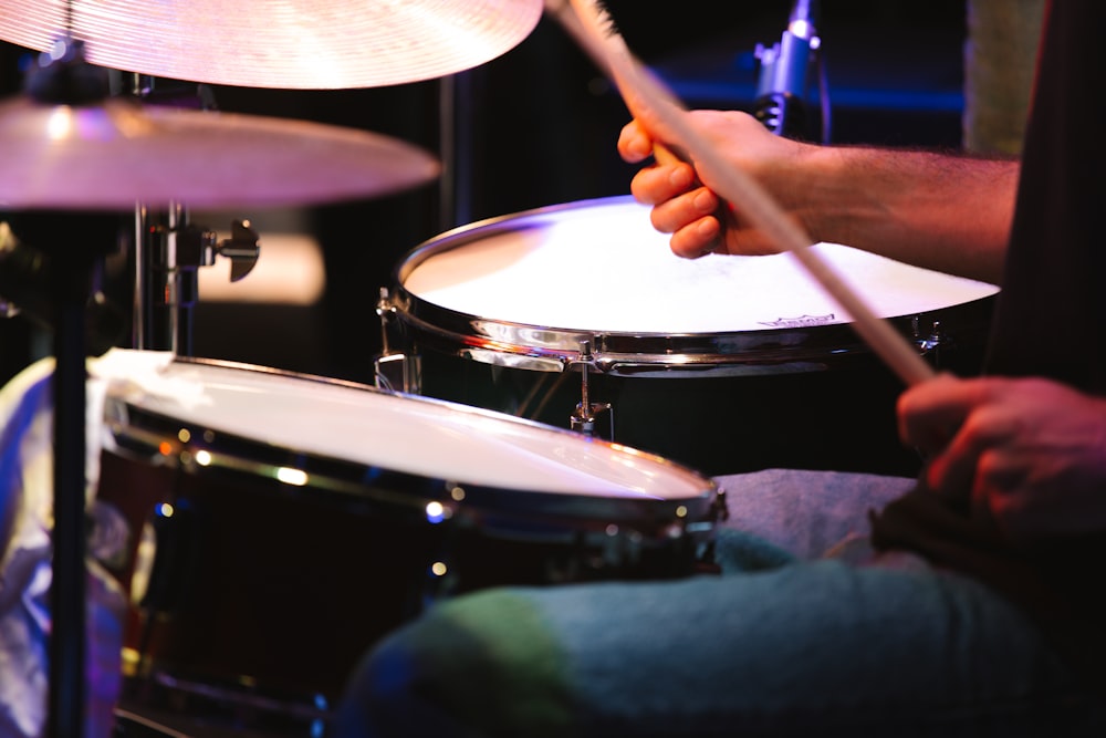 a man is playing drums in a dark room