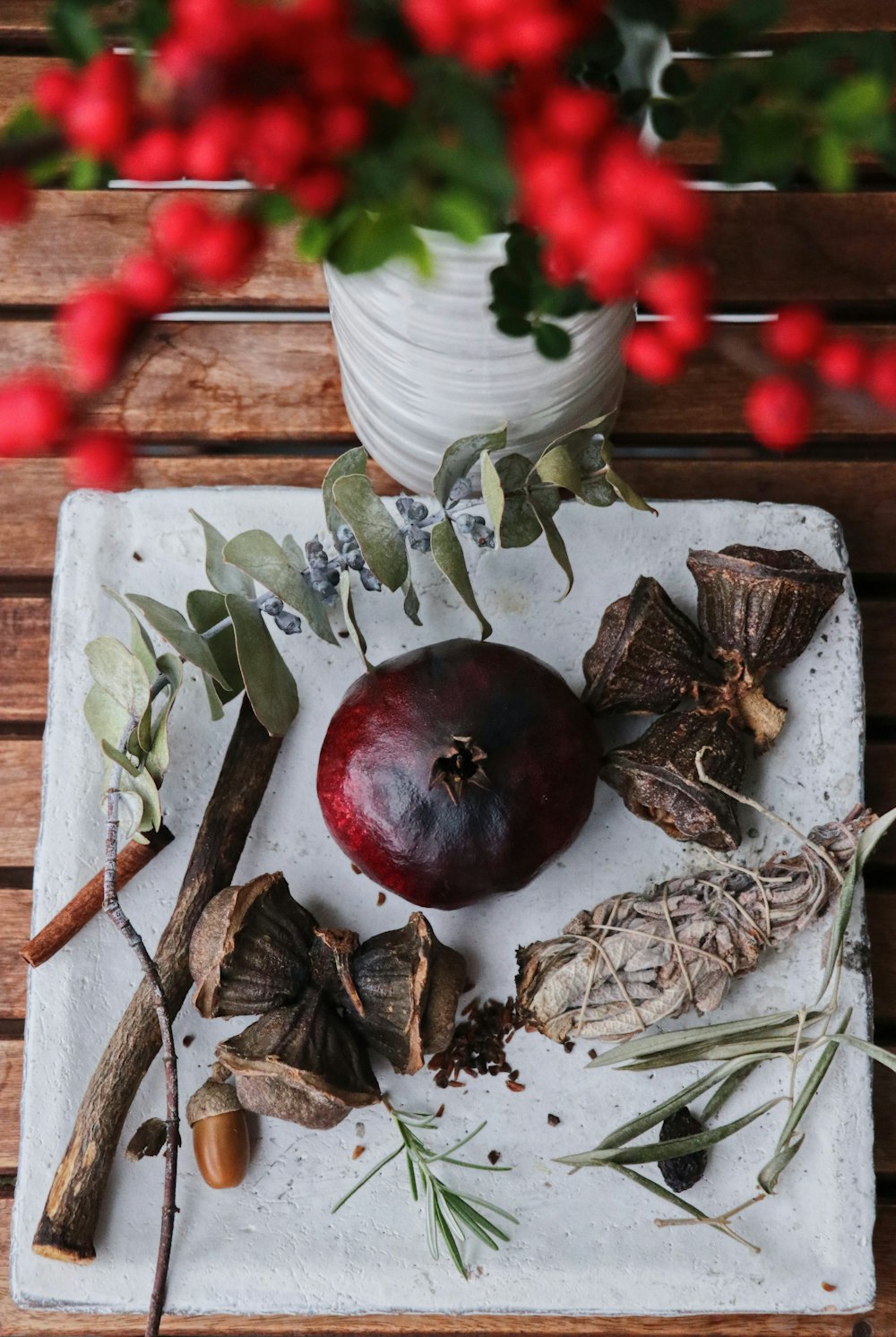 a white tray topped with a red apple next to a potted plant