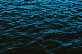A dark blue data stream flowing silently through a pitch-black background, evoking deep-sea silence and stealth.