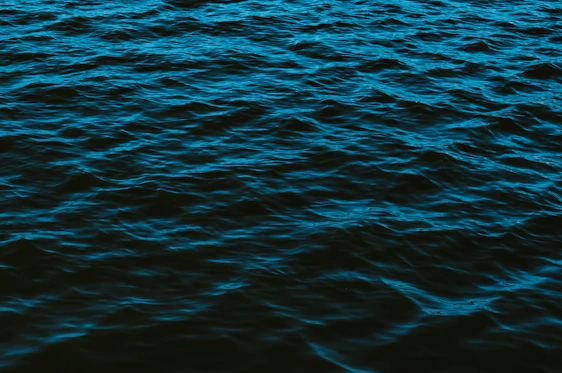 A dark blue data stream flowing silently through a pitch-black background, evoking deep-sea silence and stealth.