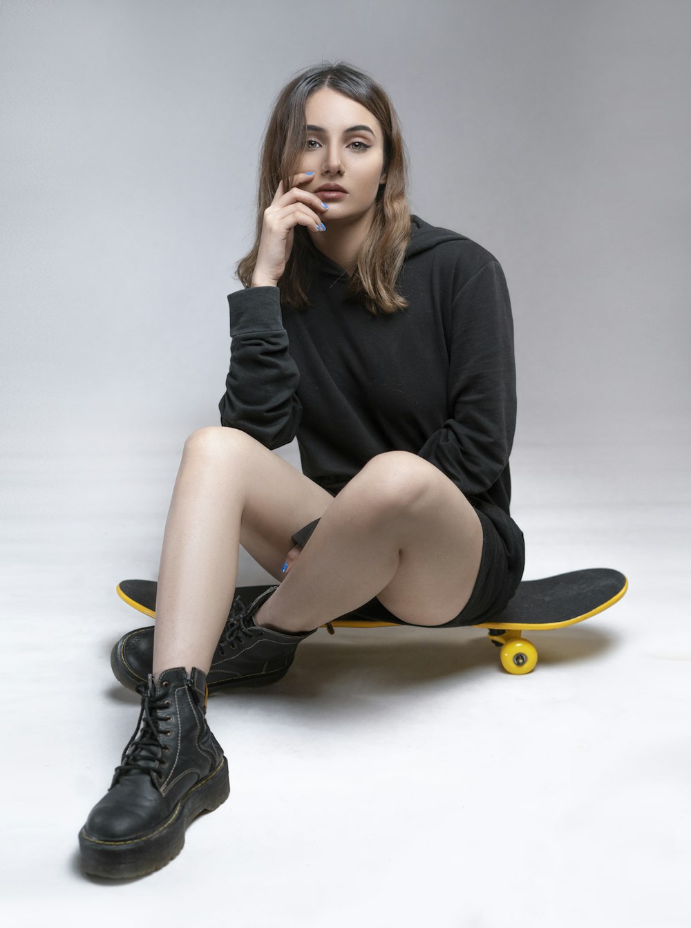 a woman sitting on top of a skateboard