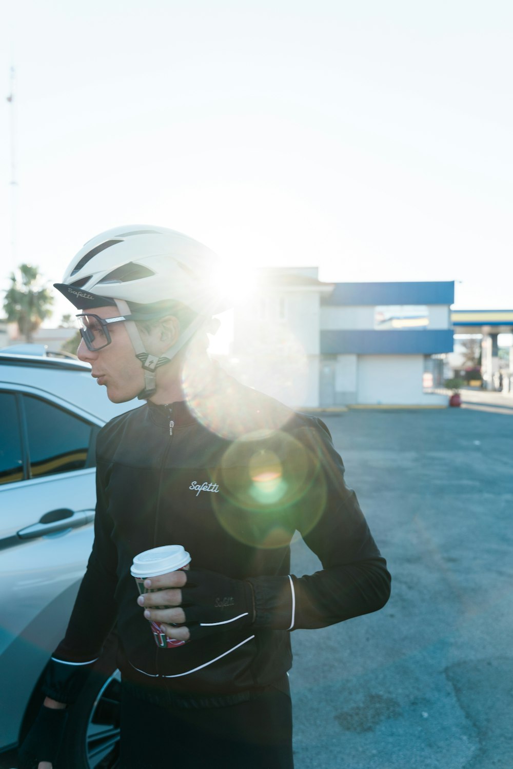 a woman wearing a helmet and holding a cup of coffee