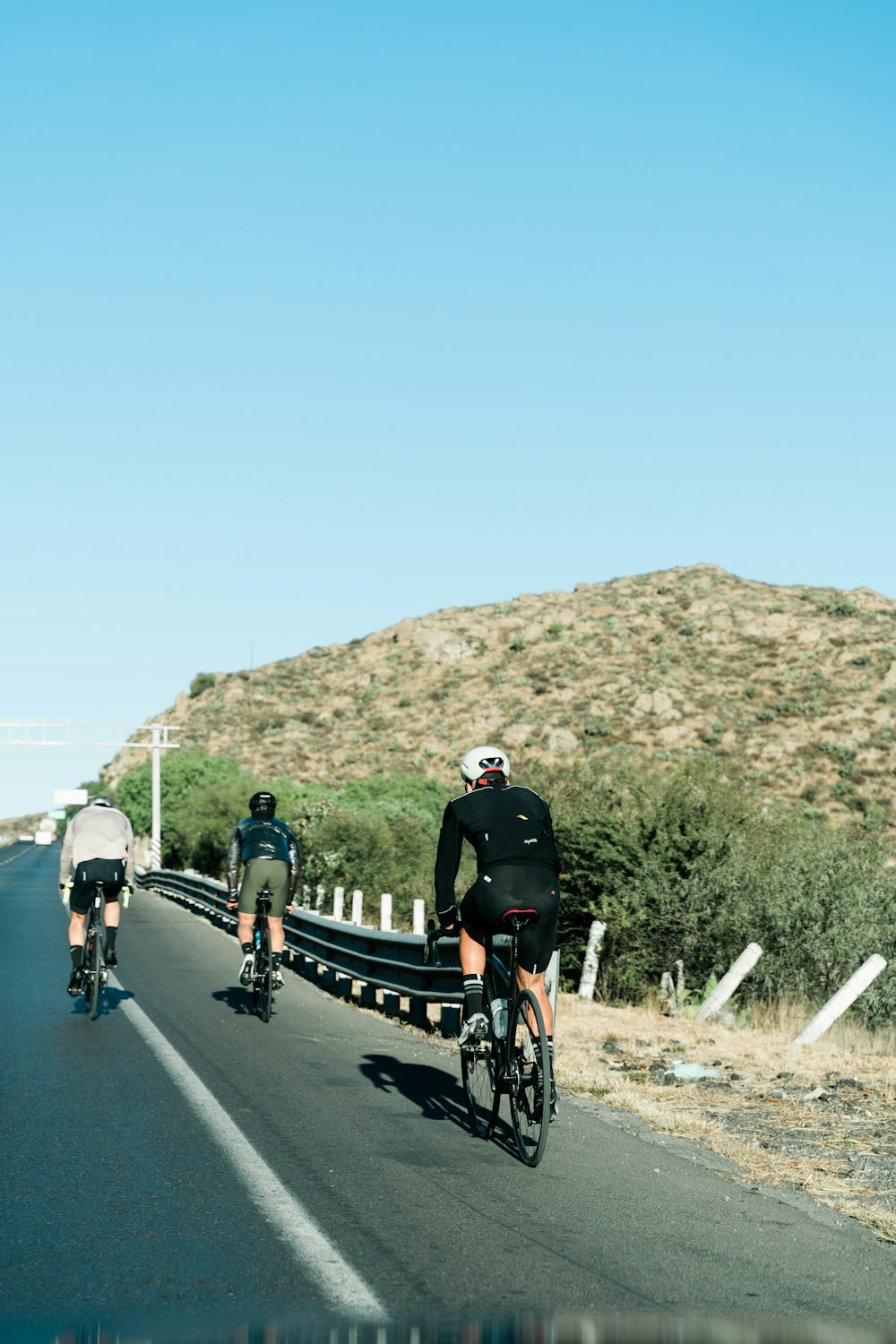 a group of bicyclists riding down a road