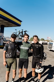 A group of cyclists smiling and comparing their Ride Like a Champ app results after a ride.