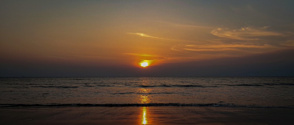 Il sole sta tramontando sull'oceano sulla spiaggia