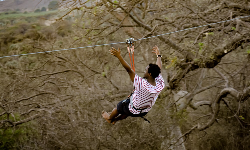 a man is high in the air on a rope