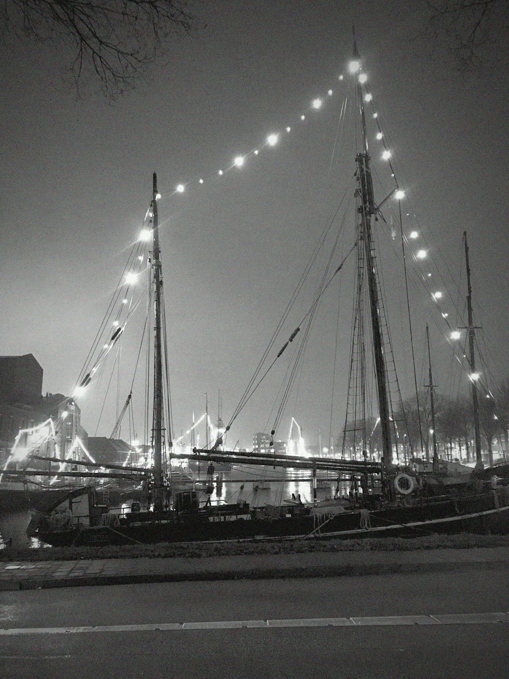 Una foto en blanco y negro de un velero por la noche