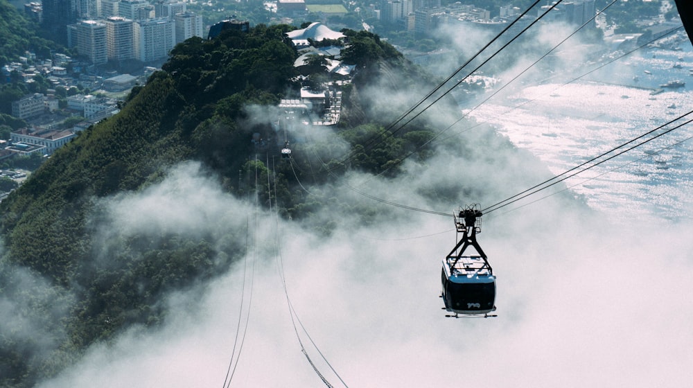 Un teleférico subiendo una montaña con una ciudad al fondo