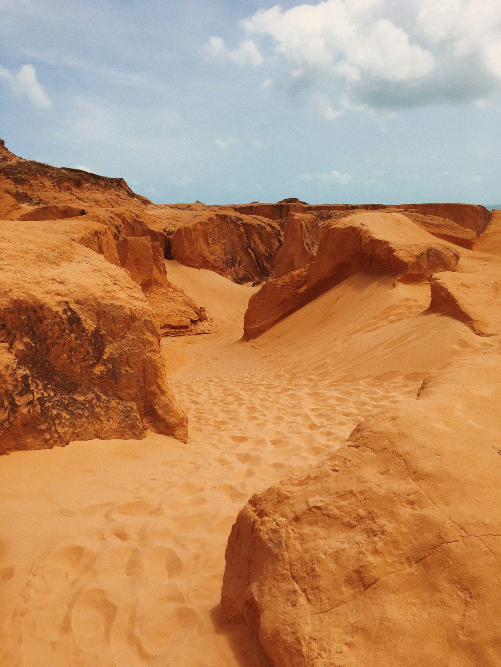 a sandy area with rocks and sand dunes