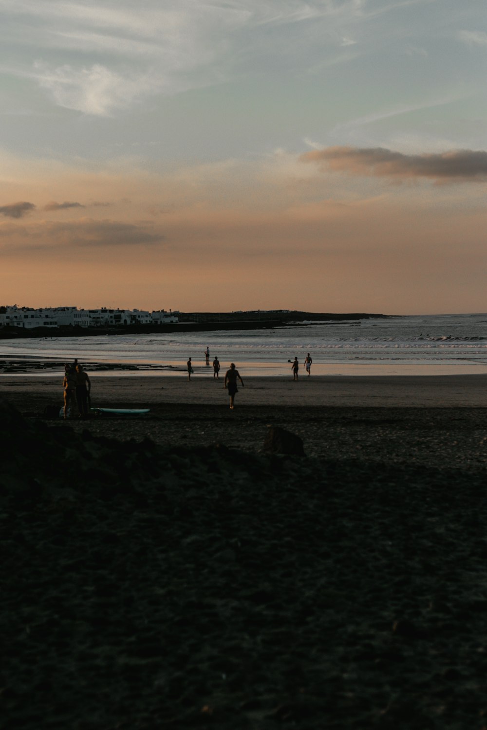 a group of people standing on top of a sandy beach