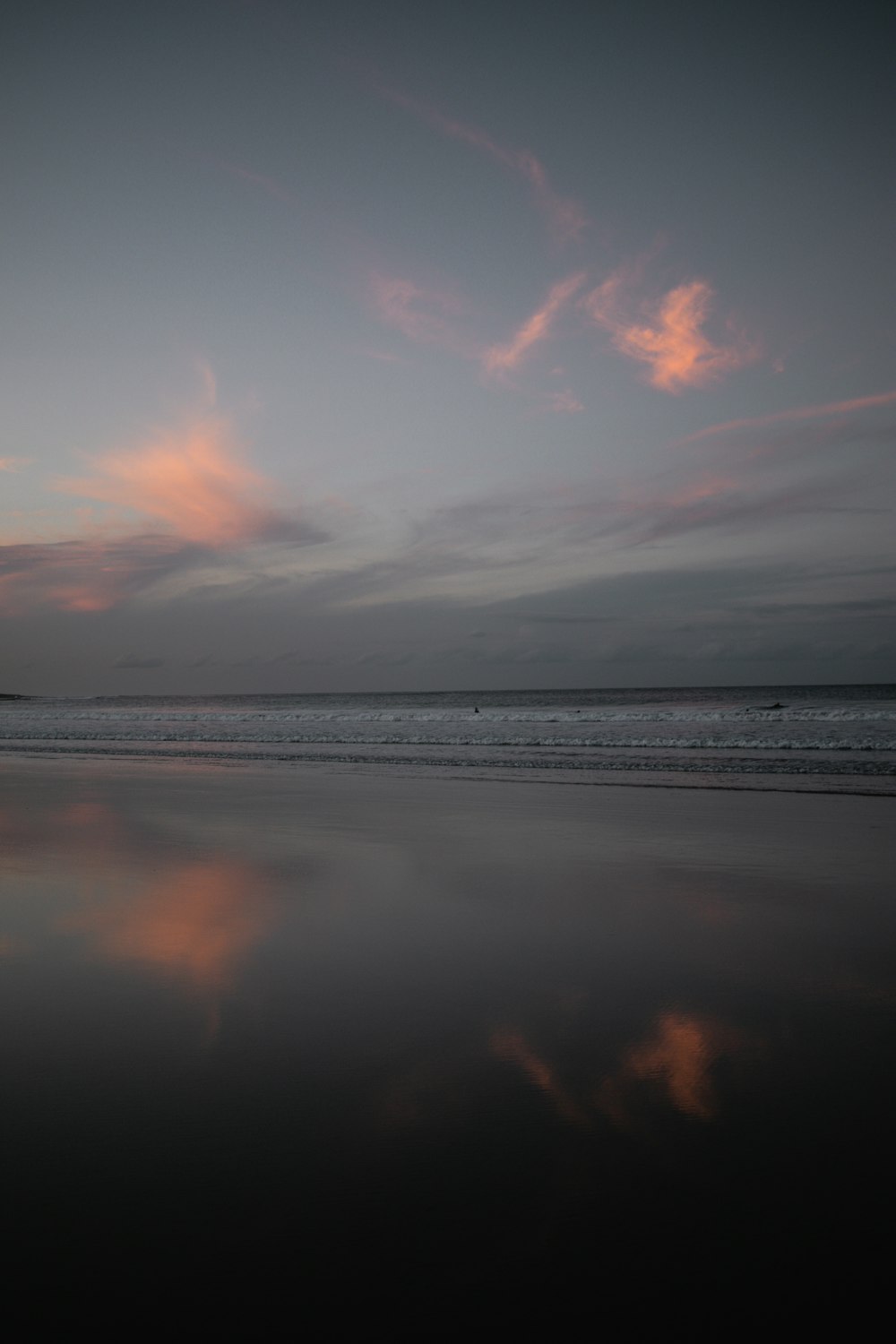 a person walking on a beach with a surfboard