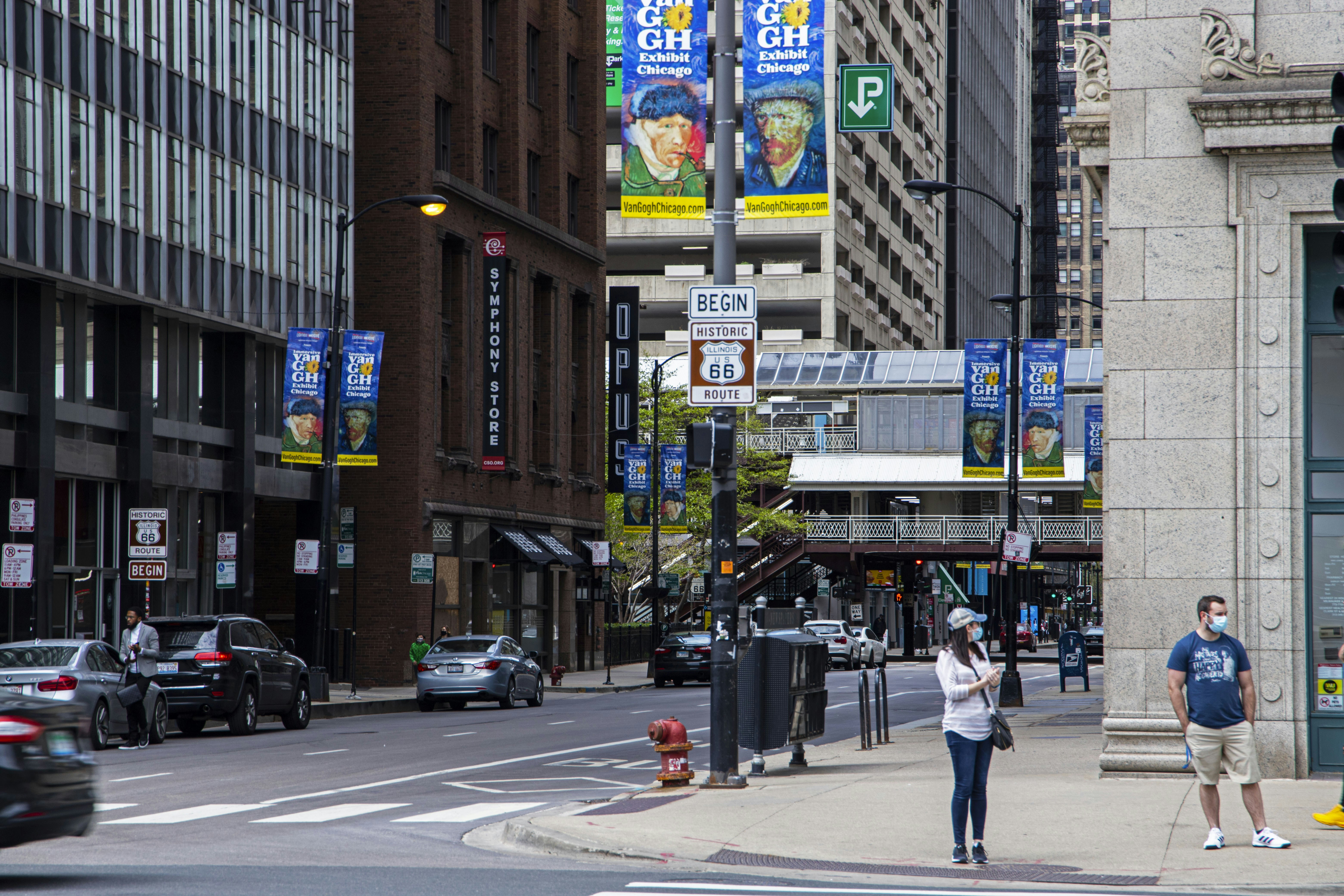 a woman standing on a sidewalk next to a traffic light