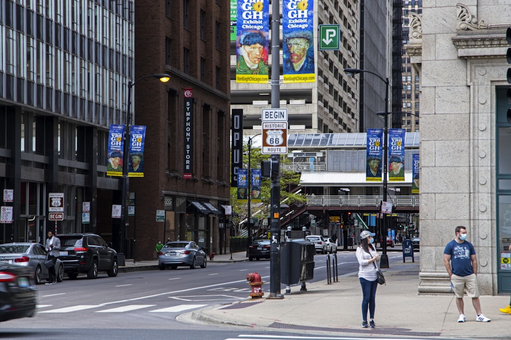 a woman standing on a sidewalk next to a traffic light