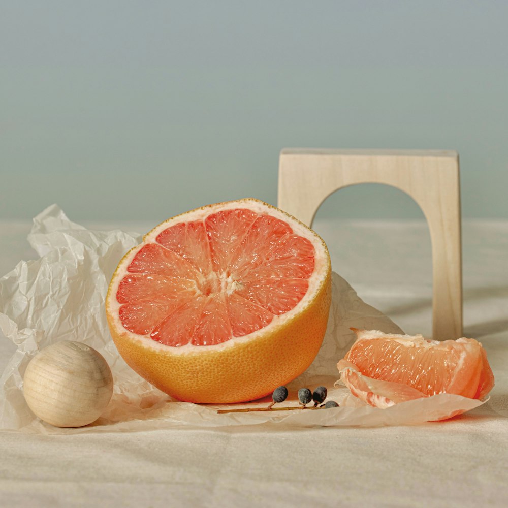 Eine in zwei Hälften geschnittene Grapefruit sitzt auf einem Tisch