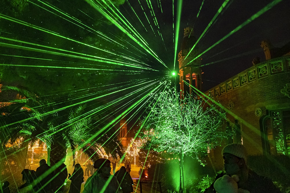 a crowd of people standing around a green laser light