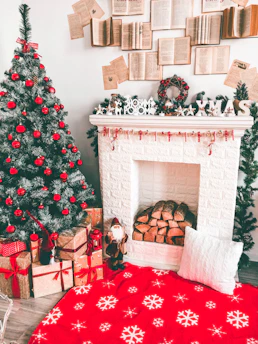 A cozy scene with holiday-themed gifts nestled by a glowing fireplace.