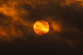 Close-up of the sun's fiery surface with swirling solar flares in vibrant orange and yellow hues.