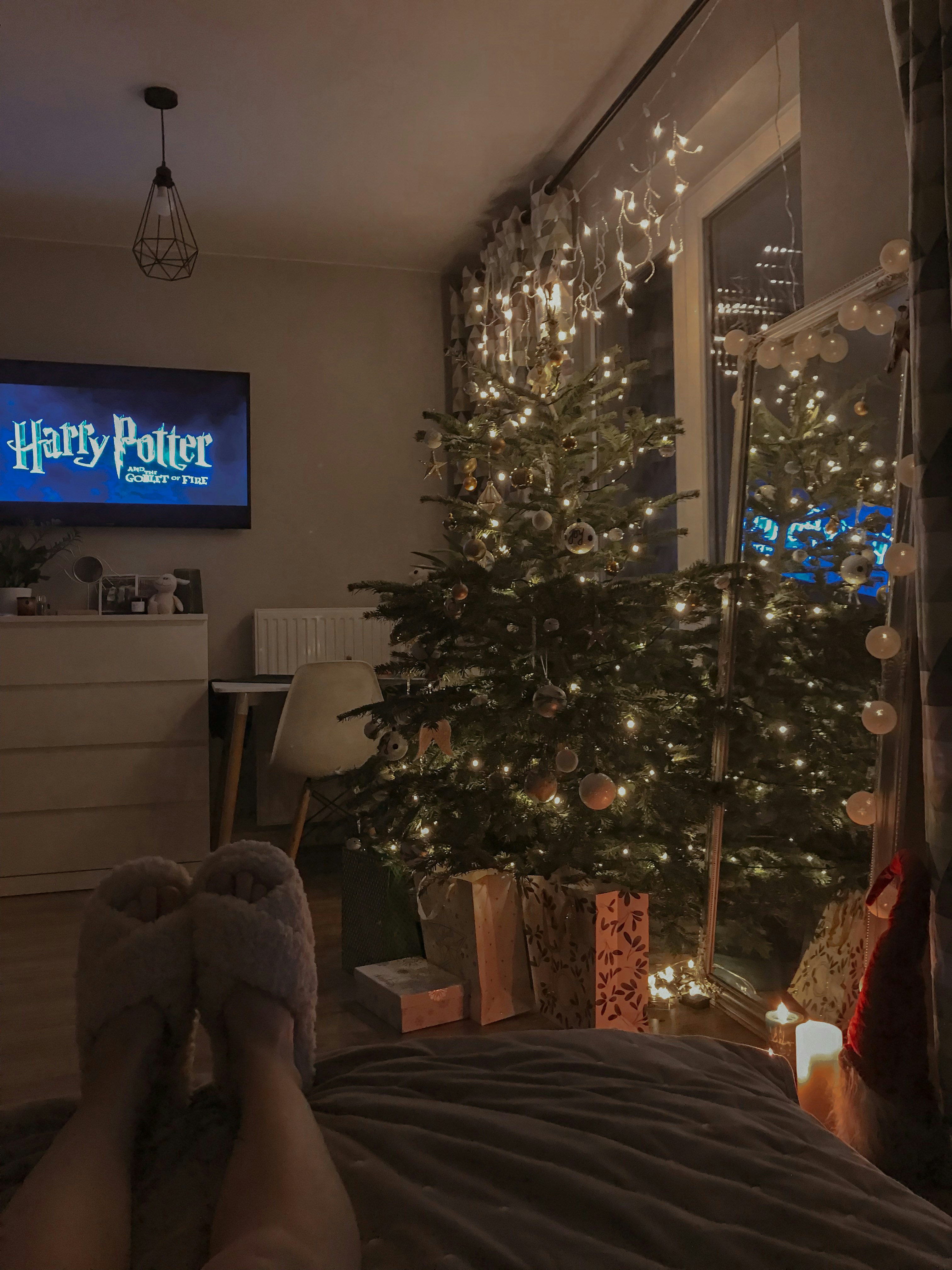 a bedroom with a christmas tree in the corner