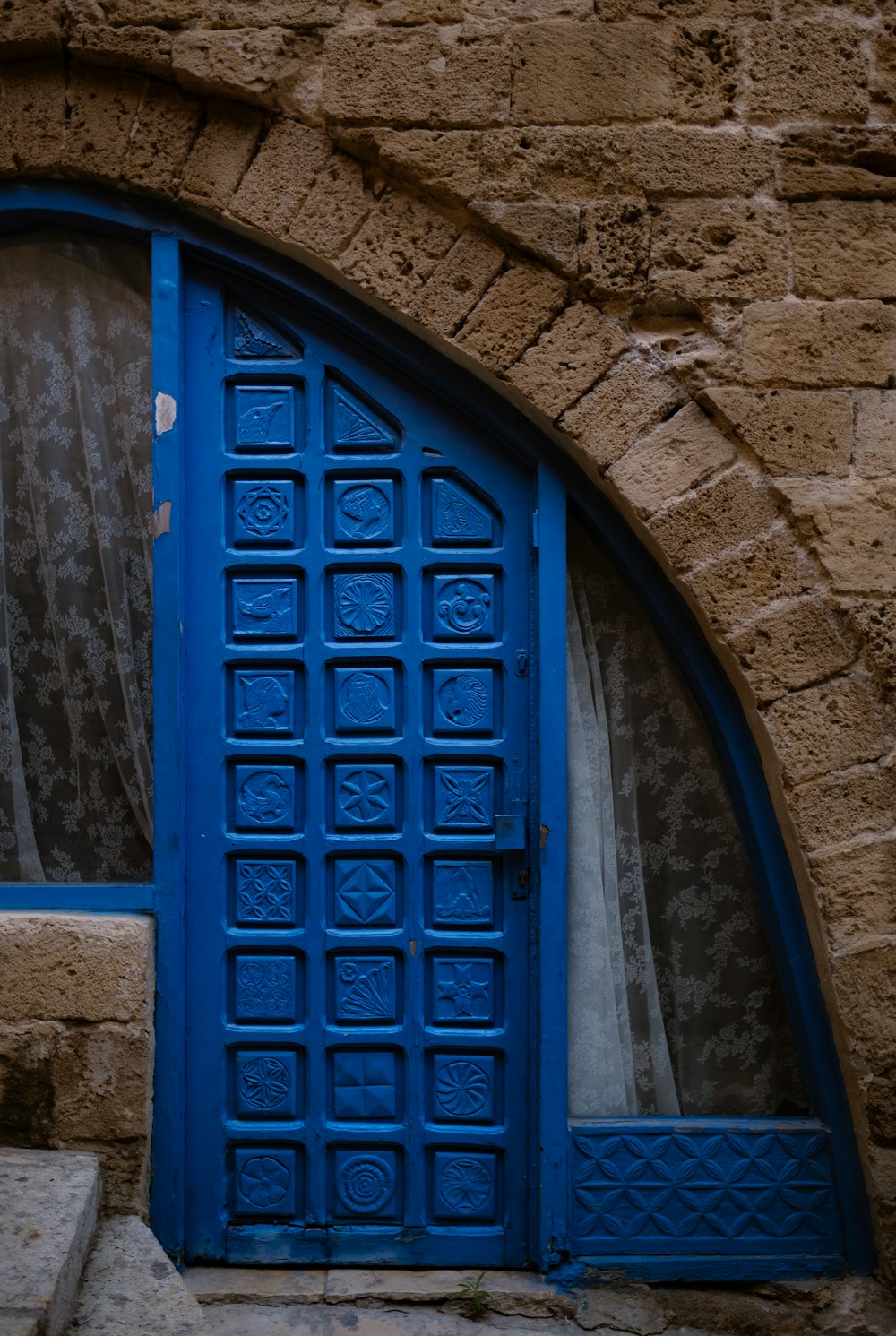 a blue door is open on a stone building