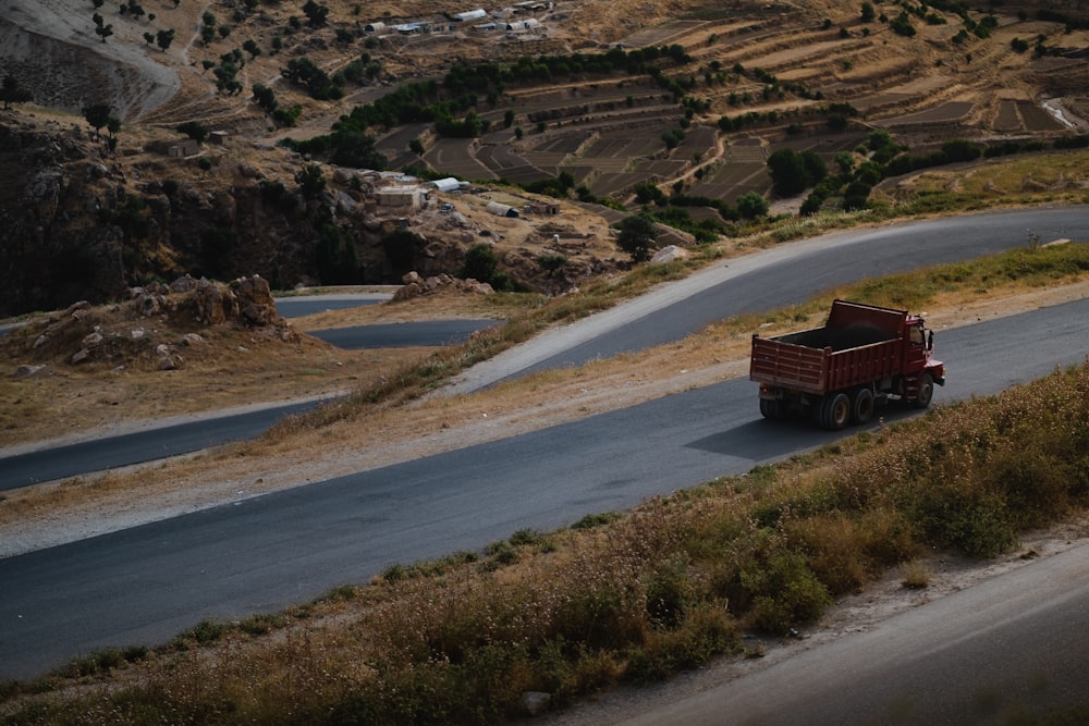 a red truck driving down a winding road