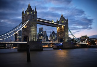the tower bridge is lit up at night